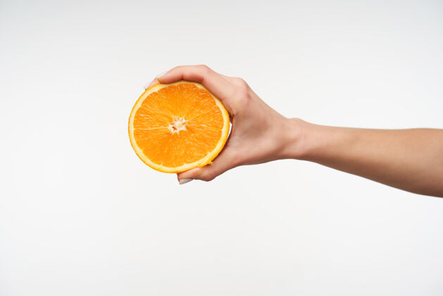 标志特写一半新鲜的橘子被年轻女子的手拿着图片果汁手势