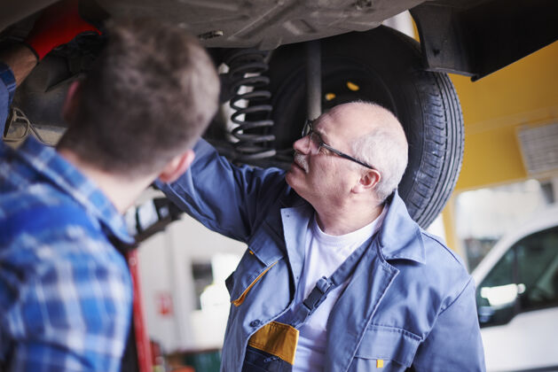 机动车修理工在车间里修理汽车伙伴关系工业体力劳动者