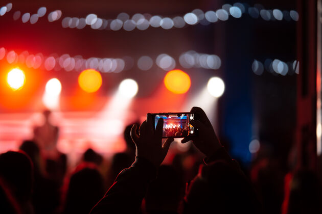 记录音乐会期间用智能手机录制视频的特写镜头色调图片表演乐队人