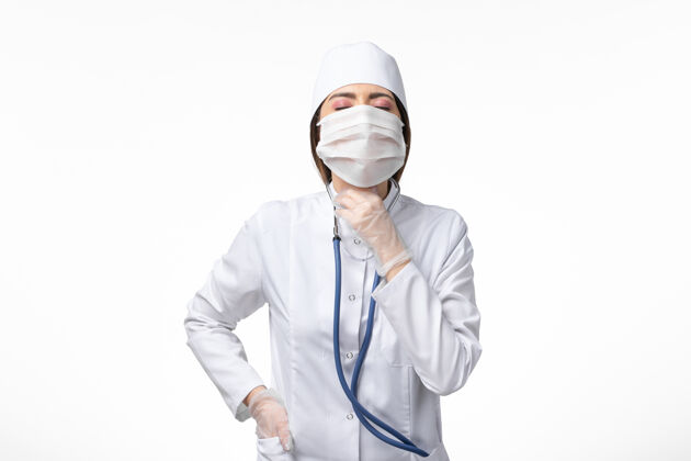 病毒正面图女医生穿着白色无菌医疗服 带口罩 因白墙上有冠状病毒病病毒冠状病毒疾病实验室外套冠状病毒防护