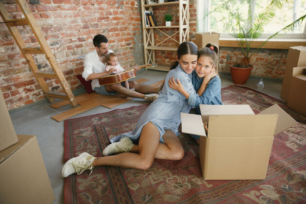 公寓新生活成年家庭搬进新房子或公寓配偶和孩子看起来快乐而自信纸板未来妻子