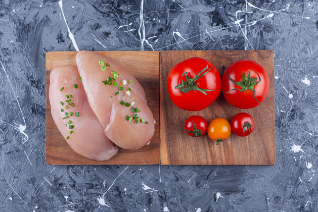 营养鸡胸肉和西红柿放在蓝色的木板上料理美味蔬菜