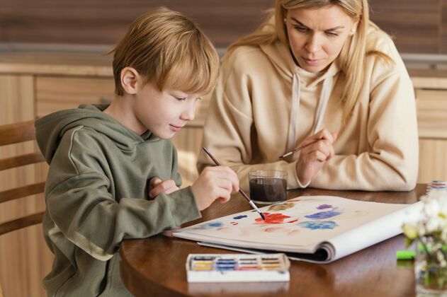绘画中镜头女人看小孩画画水平艺术生活方式