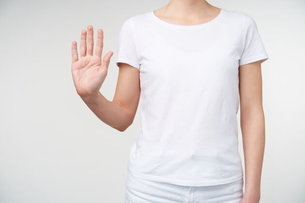 T恤这张照片是一位身穿白色t恤衫的年轻女性站在白色背景上 用手指向上指着镜头 手掌向上举作物计数手臂