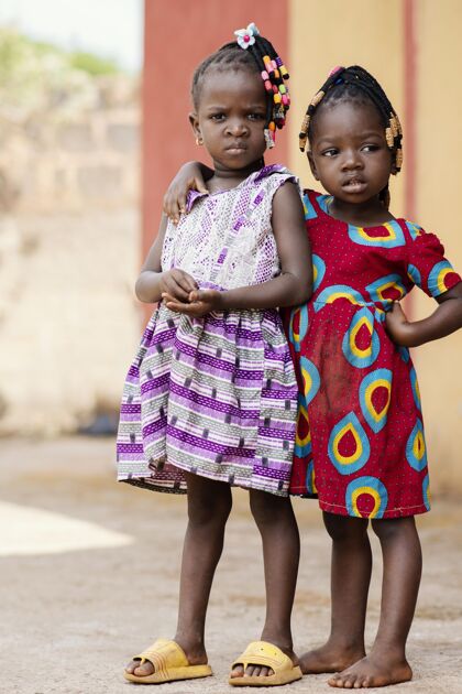 垂直全镜头可爱的非洲女孩在户外摆姿势农村非洲民族