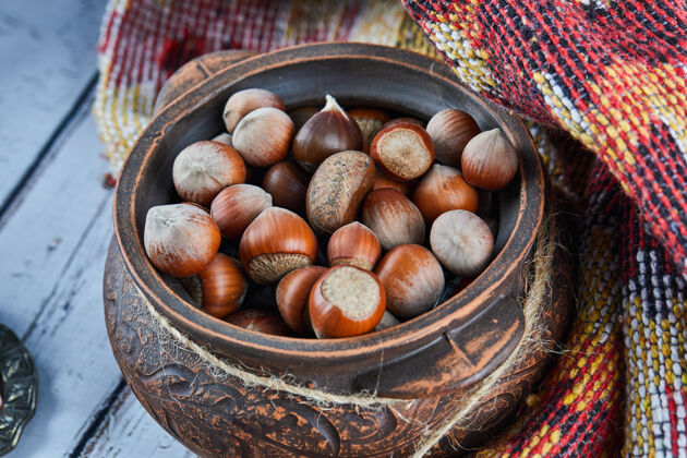地毯一碗榛子放在蓝色的木桌上 上面有雕刻的地毯阿塞拜疆木头阿塞拜疆