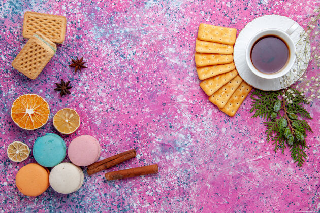 糖在粉红色的桌子上可以俯瞰法国马卡龙 还有华夫饼干和一杯茶麦卡龙饼干杯子