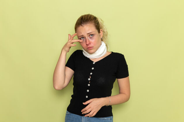 支架正面图年轻女子用白毛巾围住喉咙 感觉很不舒服 病在淡绿色的墙上 病在女人身上人女性支持