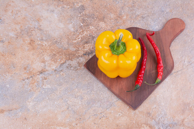 产品一个黄色的甜椒和红辣椒放在木盘上辣食物质量