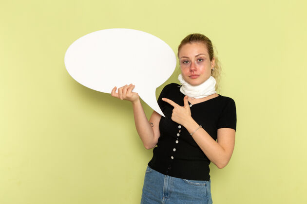 光正面图年轻女子手捧巨大的白色标牌 在淡绿色的墙上摆着病态的医药健康的姿势视图颈部支架持有