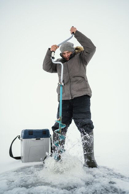 装备准备在冰冻的湖里钓鱼的人钩子诱饵放松
