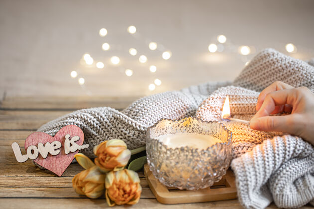 爱家庭浪漫静物与燃烧的蜡烛 装饰 鲜花和针织元素模糊的背景与波基礼物Bokeh装饰