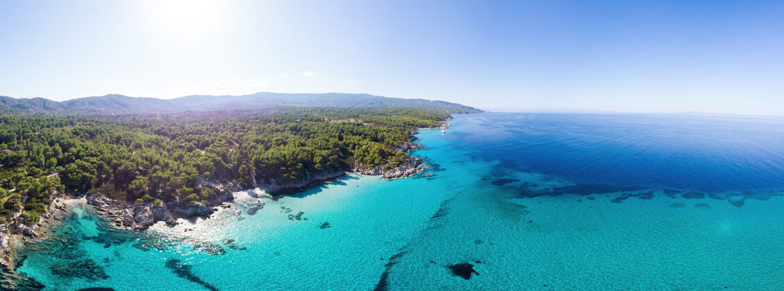 岩石爱琴海海岸的广角镜头 蓝色透明的海水 周围绿意盎然 从无人机上俯瞰帕莫拉马 希腊岩石山观点