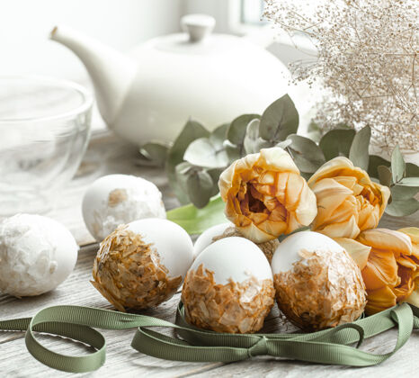 郁金香用彩蛋和鲜花装饰复活节假期的节日组成传统玻璃静物