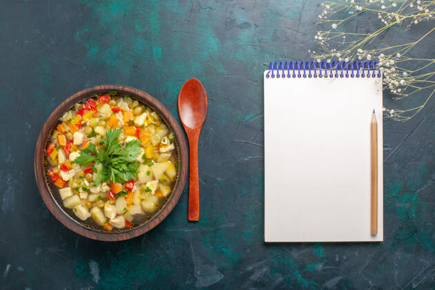 晚餐俯瞰美味的蔬菜汤与不同的配料和记事本上黑暗的书桌汤蔬菜酱食品热菜一餐菜顶部生的
