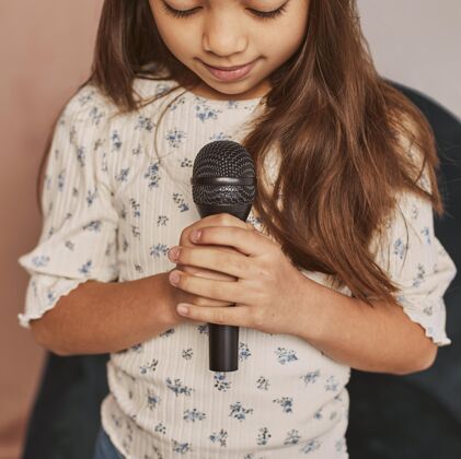 年轻人小女孩在家用麦克风学唱歌歌手孩子艺术家