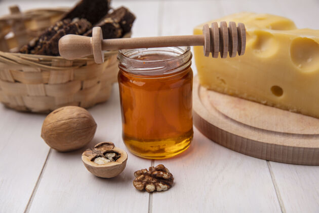 天然的前视图蜂蜜与奶酪核桃和黑面包在一个白色的背景罐面包风景奶酪