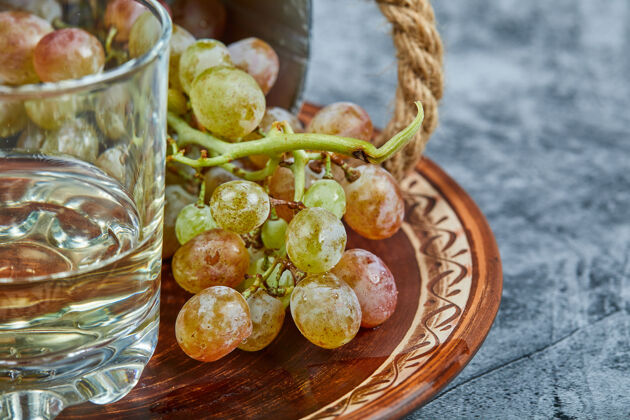 极简主义一杯白葡萄酒 周围有一束绿葡萄素食新鲜水果