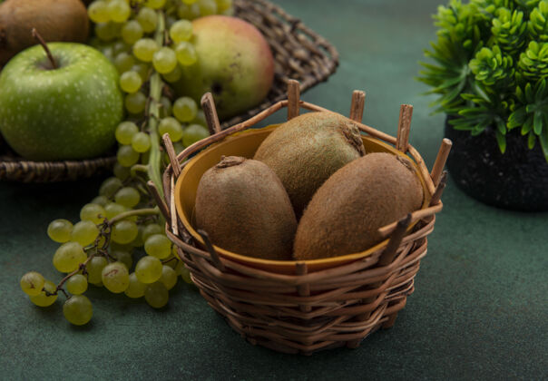 苹果正面是绿色背景上的绿色葡萄和苹果篮子里的猕猴桃篮子猕猴桃食品