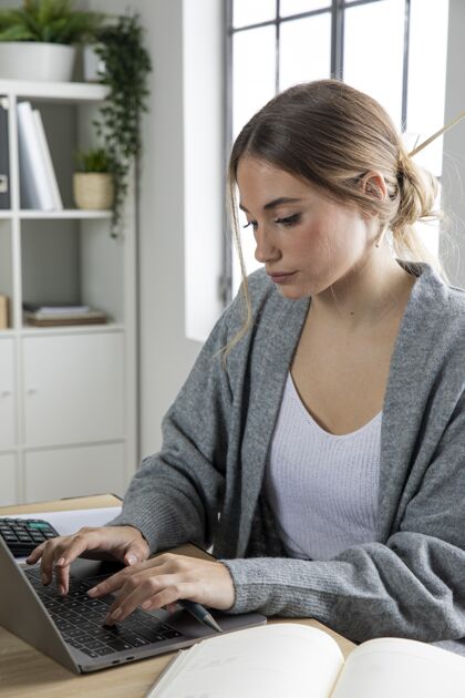 技术中等身材的女人在笔记本电脑上工作工作女性生活方式