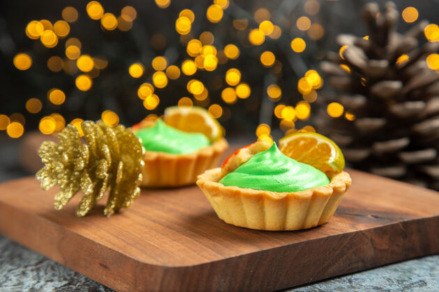 商店前视图小馅饼在砧板上圣诞饰品在黑暗的表面圣诞灯蛋糕小馅饼烘焙