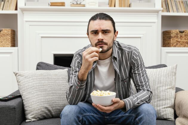 年轻吃爆米花看电视活动房子男性