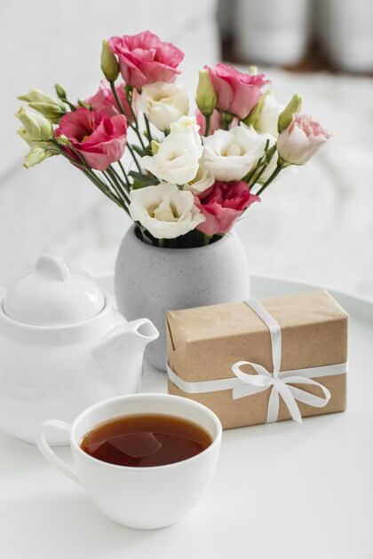 蔬菜一束玫瑰放在一个花瓶里 旁边是一个包装好的礼物季节开花花