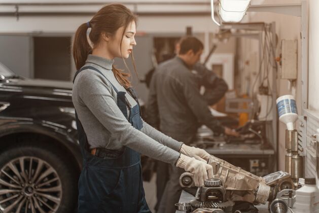 女性侧视图在汽车服务公司工作的女人女性气质独立工作