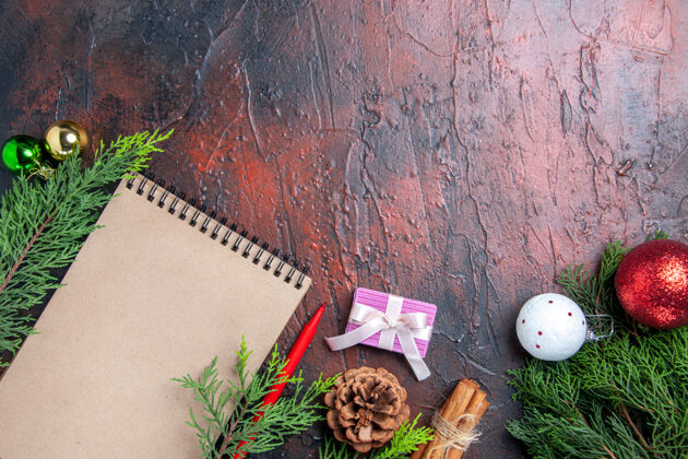 背景顶视图红笔笔记本松树树枝圣诞树玩具和礼品八角茴香草线暗红色桌上免费的地方钢笔玩具稻草
