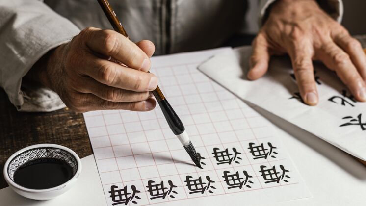 安排在白纸上写中国符号的人高角度水墨中国水墨