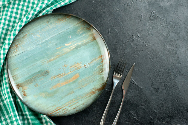 厨具顶视图圆形拼盘叉和刀绿色和白色桌布黑色桌子上的自由空间桌布炒锅推车