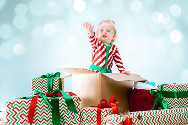 宝贝可爱的女婴1岁坐在盒子里过圣诞节房子礼物惊喜