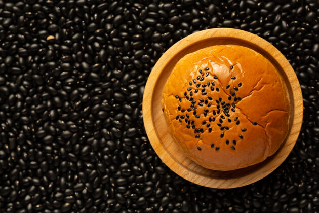 滋养木盘上烤豆沙包放在满是黑豆的地板上餐饮自然服务