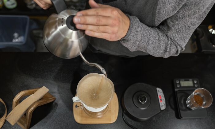 服务员男咖啡师在咖啡过滤器里倒开水职业职业水平