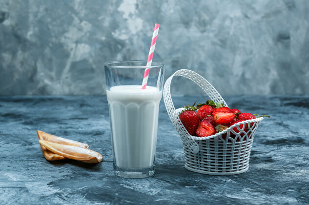 罐子在深蓝色和灰色大理石背景上 用一壶牛奶和椰子片合上一篮草莓水平篮子浆果农场