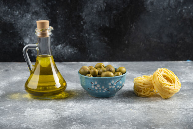 干的石桌上有面条 油和青橄榄面条意大利面油