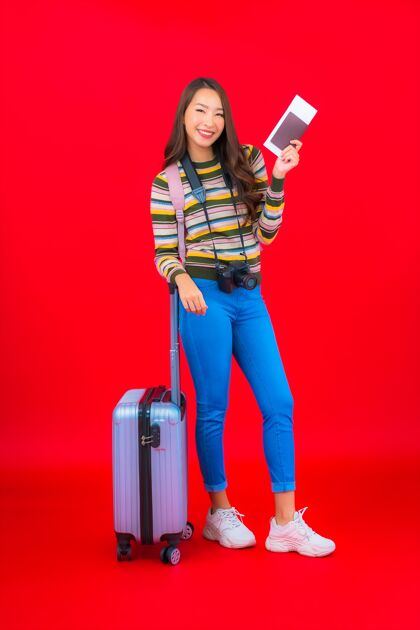 亚洲画像美丽的亚洲年轻女子带着行李和登机牌在红墙上旅行旅行者女性