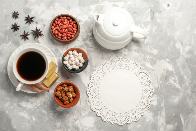杯子顶视图一杯茶 白色表面有坚果和饼干瓷器器皿茶
