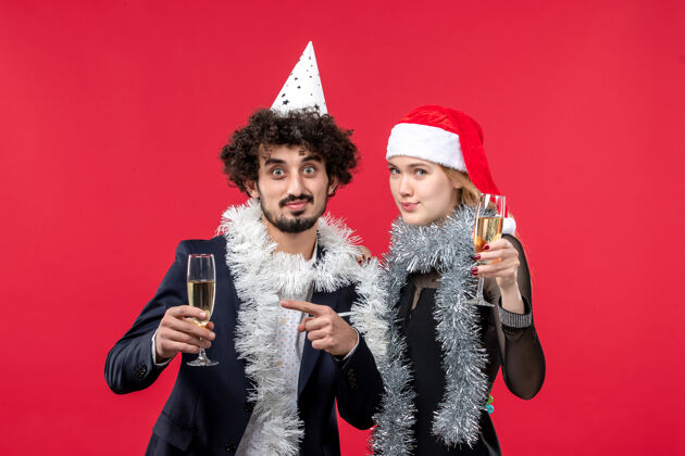 圣诞正面图年轻夫妇在红桌假日庆祝新年圣诞之爱成人帽子肖像