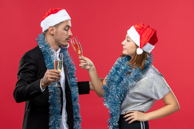 帽子前视图年轻夫妇刚刚在红墙派对上庆祝新年圣诞之爱表演微笑男人