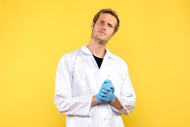服装正面图黄色背景上的年轻男医生人类共济会医疗大流行人类医院实验室
