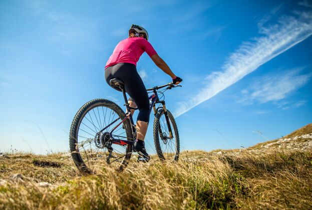 自行车阳光明媚的斯洛文尼亚纳诺高原上的女山地车手爱好女性阿尔卑斯山