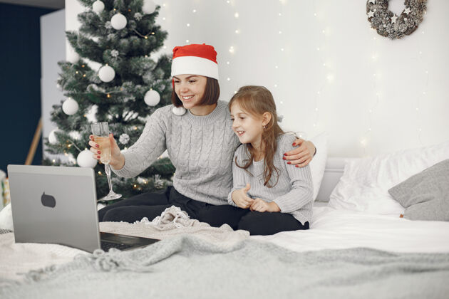 设备圣诞节在线庆祝圣诞节新年在封锁冠状病毒检疫党在线母亲与女儿笔记本电脑十二月病毒