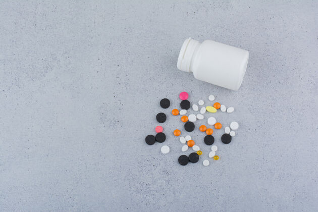 医药白色的容器和一堆各种各样的药丸放在大理石表面止痛药瓶子药丸瓶