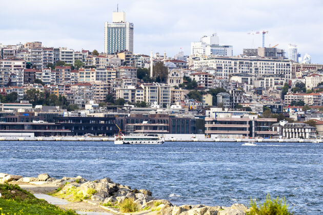 城市伊斯坦布尔的一个住宅区和现代化的高层建筑 博斯普鲁斯海峡的船只 人们在岸边休息 土耳其欧罗巴全景城市景观