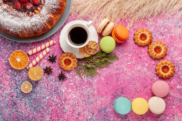 饼干顶视图一杯茶 粉红色桌子上放着饼干和麦卡龙 烤蛋糕 饼干 甜甜的糖香料顶部烘焙