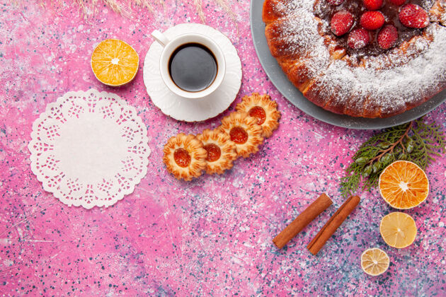 顶部俯瞰美味的草莓蛋糕 配上饼干和一杯茶 放在粉红色的桌子上 蛋糕烤甜糖饼干 饼干 彩色馅饼蛋糕颜色美食