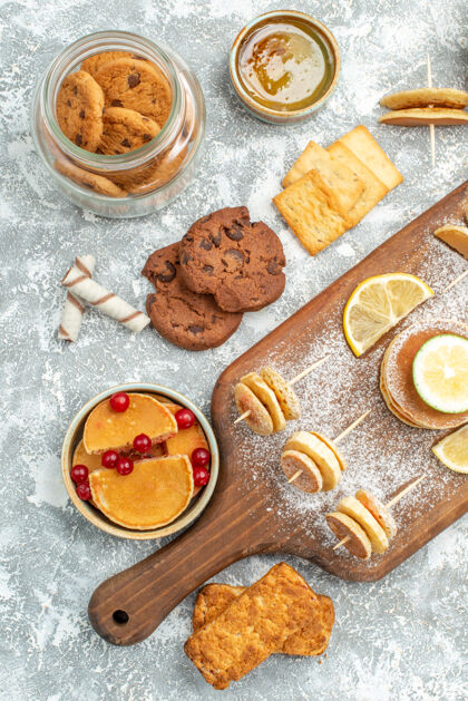 甜点简单的煎饼的垂直视图 切菜板上有柠檬 蓝色上有蜂蜜饼干食物小吃甜点