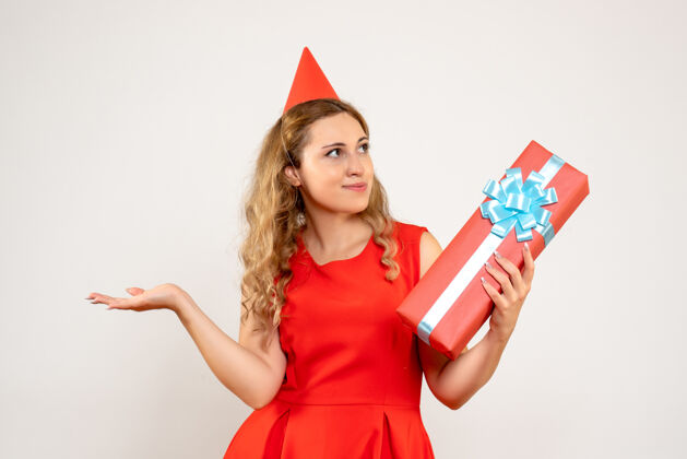 圣诞正面图身着红色连衣裙的年轻女性用礼物庆祝圣诞节幸福庆祝颜色