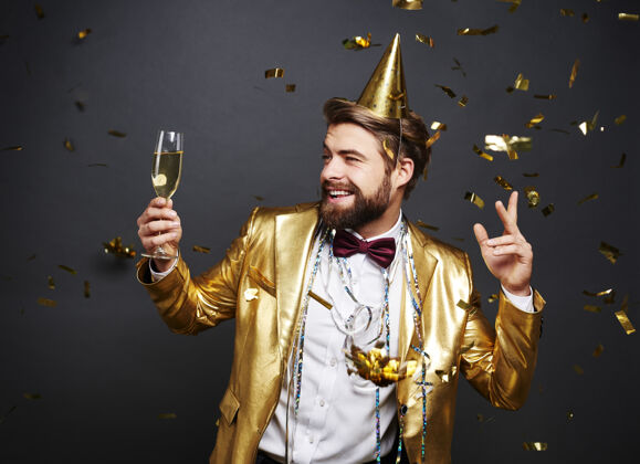 庆祝手持香槟长笛的男人在迎接新年庆祝活动西装迪斯科